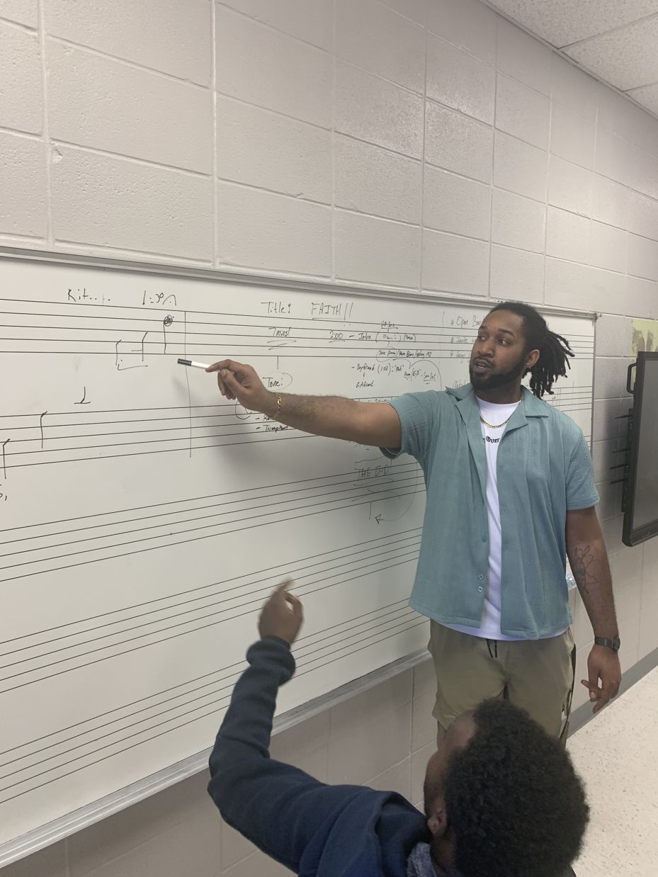 Kalif teaching music at the whiteboard